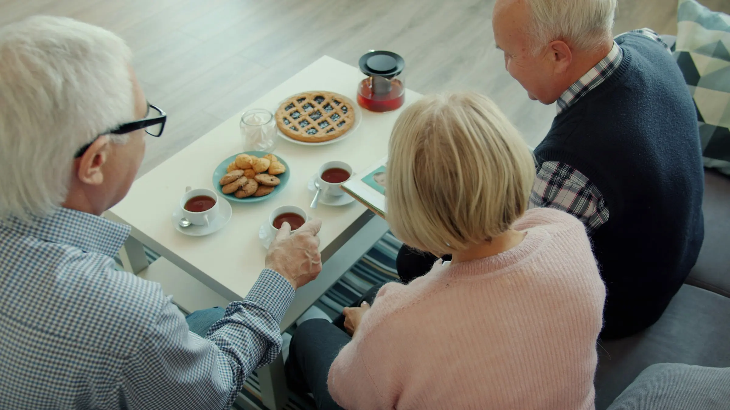 Älteres Paar schaut gemeinsam alte Familienfotos an